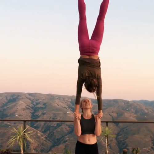 Standing acrobatics / acroyoga where Camilla is lady basing Emily in a hand-to-hand