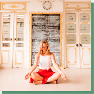 Camilla Mia sitting in a meditation cross-legged position on the floor in Bali during her yoga teacher training.
