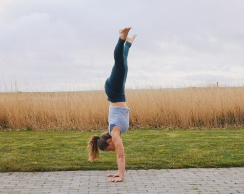 Camilla doing an open straddle handstand seen from the side