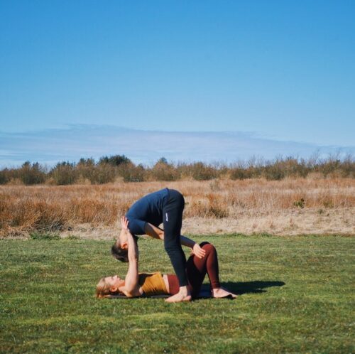 Entry into shoulderstand on knees pose from acroyoga, which is one of the intermediate friendly acroyoga poses