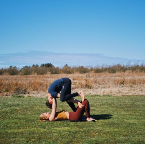 Entry into shoulderstand on knees pose from acroyoga, which is one of the intermediate friendly acroyoga poses