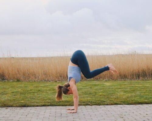 Camilla jumping into a tuck shape freestanding handstand