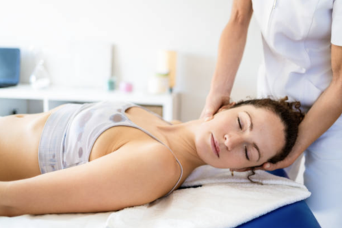 Osteopathic treatment in Copenhagen, where the client is lying on the treatment table and the osteopath is mobilising the neck