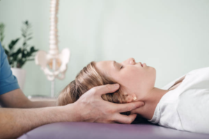 Viser hvordan osteopatisk behandling foregår med en osteopat, der har hænderne på et hoved af en klient i gang med en kraniosakral teknik i den osteopatiske behandling.